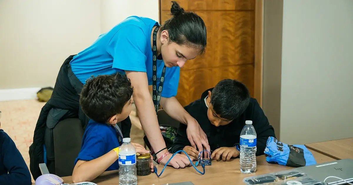 An instructor helping students with Arduino