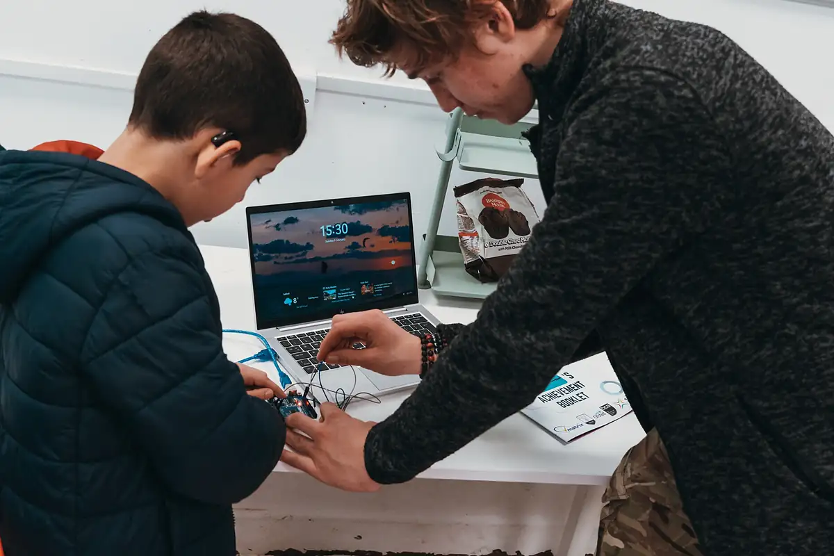 A teacher helping a student with wiring