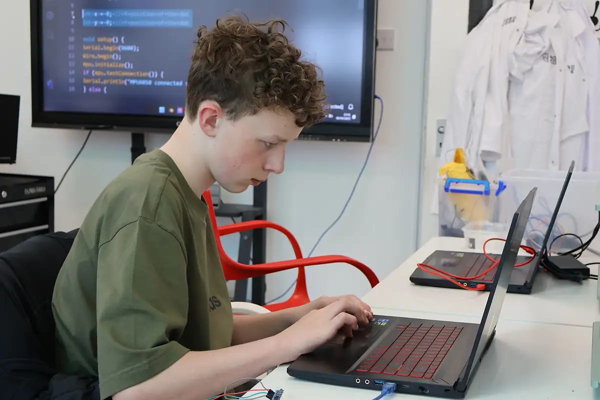 A student coding on a laptop